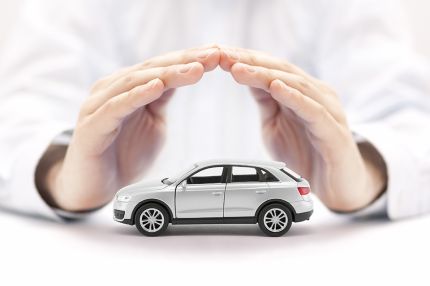 Foto: Hände über kleinem Auto